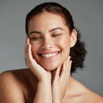 Face, beauty and satisfaction with a model black woman in studio on a gray background to promote natural skincare. Facial, wellness and makeup with an attractive young female happy with cosmetics